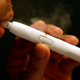 A man uses a Philip Morris iQOS e-cigarette in Tokyo.